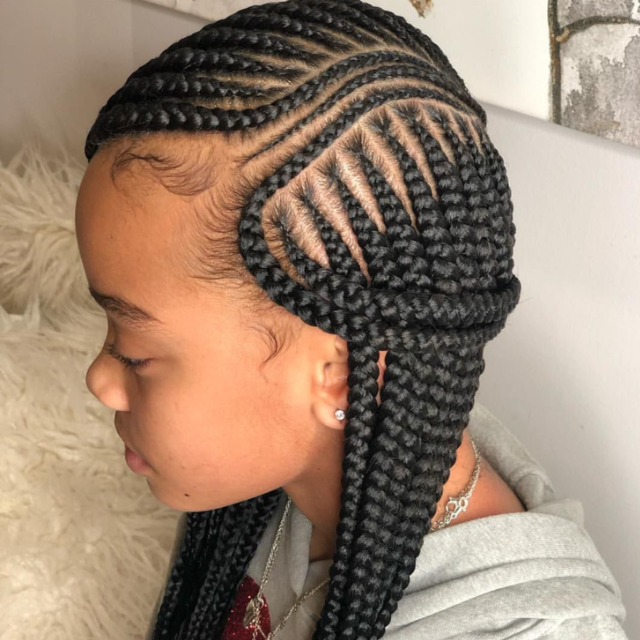 Two neatly braided French braids on a child's head, secured with hair ties